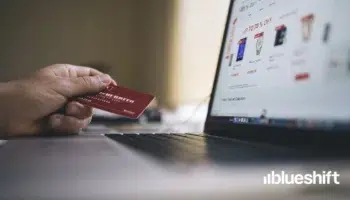 Person online shopping on a laptop with credit card in hand