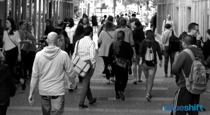 A crowd of people walking in a city