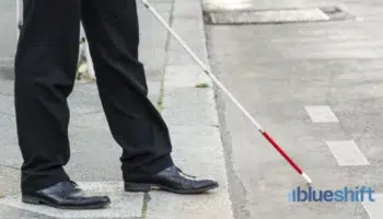 A person with a walking stick stepping out into the street
