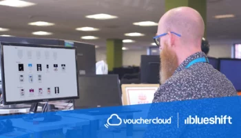 Vouchercloud and Blueshift logos under an image of a man working at a computer in an office setting