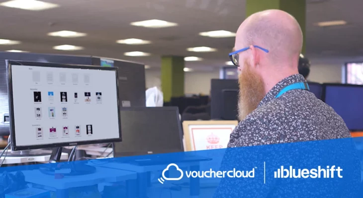 Vouchercloud and Blueshift logos under an image of a man working at a computer in an office setting