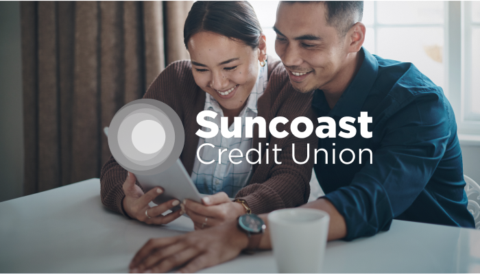 man and woman are smiling and looking at a tablet together with an "ent credit union" logo laid overtop